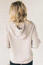 BLONDE WOMAN WEARING A SOLID COLOR ACID WASH FLEECE OVERSIZED 1/4 ZIP KANGAROO POCKET HOODIE.