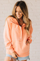 BLONDE WOMAN WEARING A SOLID COLOR ACID WASH FLEECE OVERSIZED 1/4 ZIP KANGAROO POCKET HOODIE.