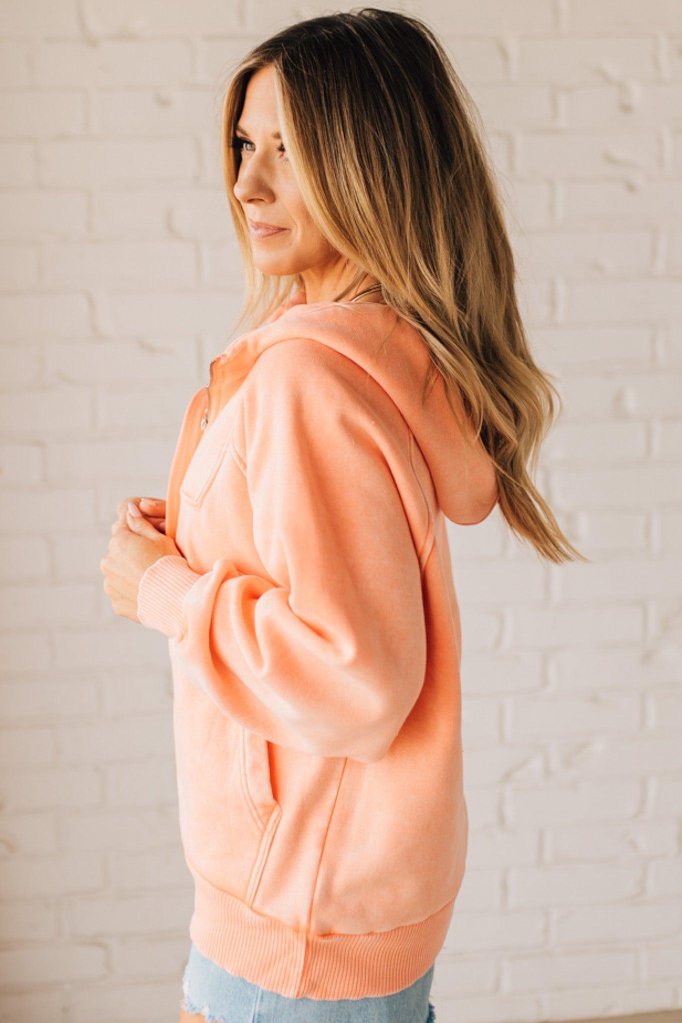 BLONDE WOMAN WEARING A SOLID COLOR ACID WASH FLEECE OVERSIZED 1/4 ZIP KANGAROO POCKET HOODIE.