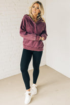 BLONDE WOMAN WEARING A SOLID COLOR ACID WASH FLEECE OVERSIZED 1/4 ZIP KANGAROO POCKET HOODIE.