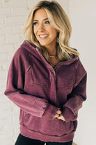 BLONDE WOMAN WEARING A SOLID COLOR ACID WASH FLEECE OVERSIZED 1/4 ZIP KANGAROO POCKET HOODIE.