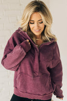 BLONDE WOMAN WEARING A SOLID COLOR ACID WASH FLEECE OVERSIZED 1/4 ZIP KANGAROO POCKET HOODIE.