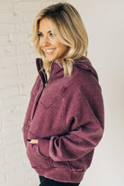 BLONDE WOMAN WEARING A SOLID COLOR ACID WASH FLEECE OVERSIZED 1/4 ZIP KANGAROO POCKET HOODIE.
