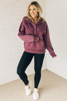 BLONDE WOMAN WEARING A SOLID COLOR ACID WASH FLEECE OVERSIZED 1/4 ZIP KANGAROO POCKET HOODIE.
