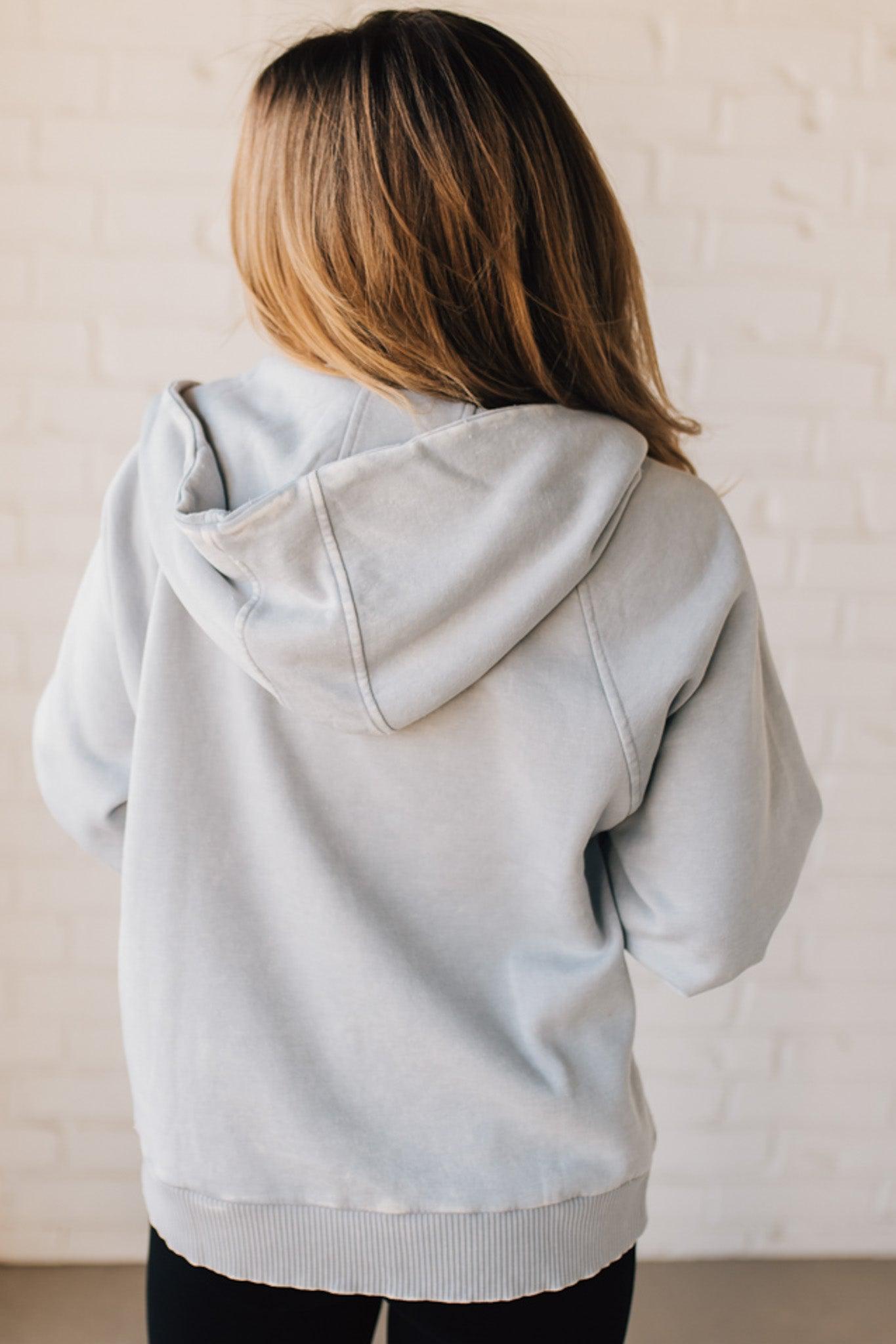 BLONDE WOMAN WEARING A SOLID COLOR ACID WASH FLEECE OVERSIZED 1/4 ZIP KANGAROO POCKET HOODIE.