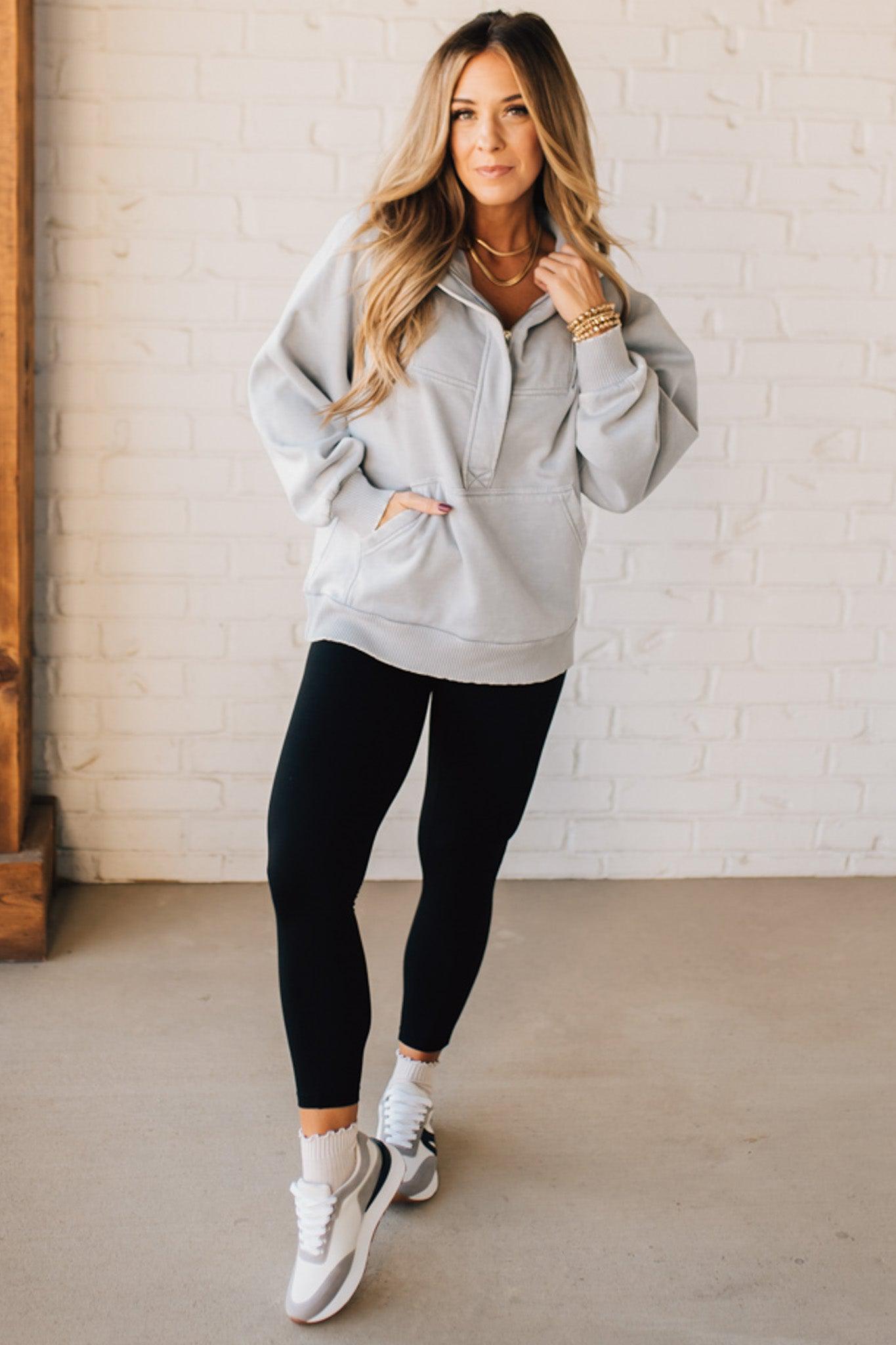 BLONDE WOMAN WEARING A SOLID COLOR ACID WASH FLEECE OVERSIZED 1/4 ZIP KANGAROO POCKET HOODIE.