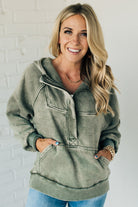 BLONDE WOMAN WEARING A SOLID COLOR ACID WASH FLEECE OVERSIZED 1/4 ZIP KANGAROO POCKET HOODIE.