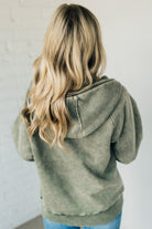 BLONDE WOMAN WEARING A SOLID COLOR ACID WASH FLEECE OVERSIZED 1/4 ZIP KANGAROO POCKET HOODIE.