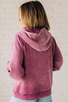BLONDE WOMAN WEARING A SOLID COLOR ACID WASH FLEECE OVERSIZED 1/4 ZIP KANGAROO POCKET HOODIE.