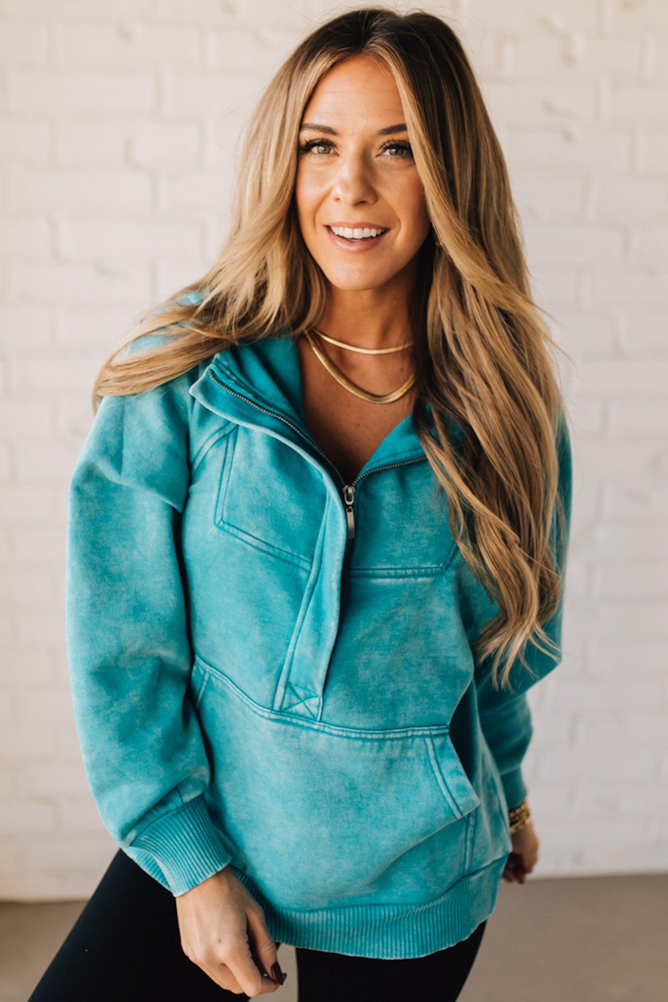 BLONDE WOMAN WEARING A SOLID COLOR ACID WASH FLEECE OVERSIZED 1/4 ZIP KANGAROO POCKET HOODIE.