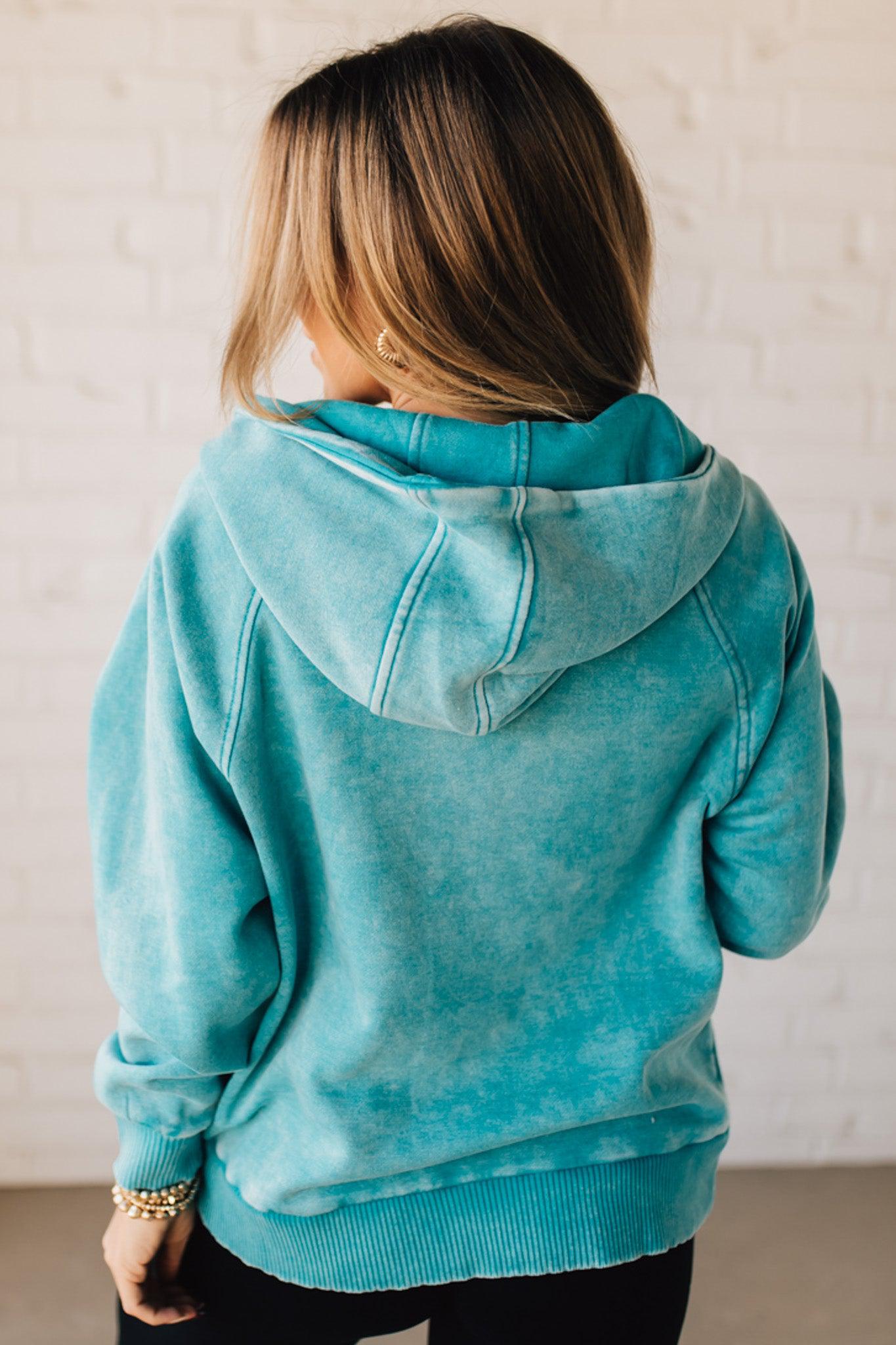 BLONDE WOMAN WEARING A SOLID COLOR ACID WASH FLEECE OVERSIZED 1/4 ZIP KANGAROO POCKET HOODIE.