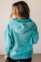 BLONDE WOMAN WEARING A SOLID COLOR ACID WASH FLEECE OVERSIZED 1/4 ZIP KANGAROO POCKET HOODIE.