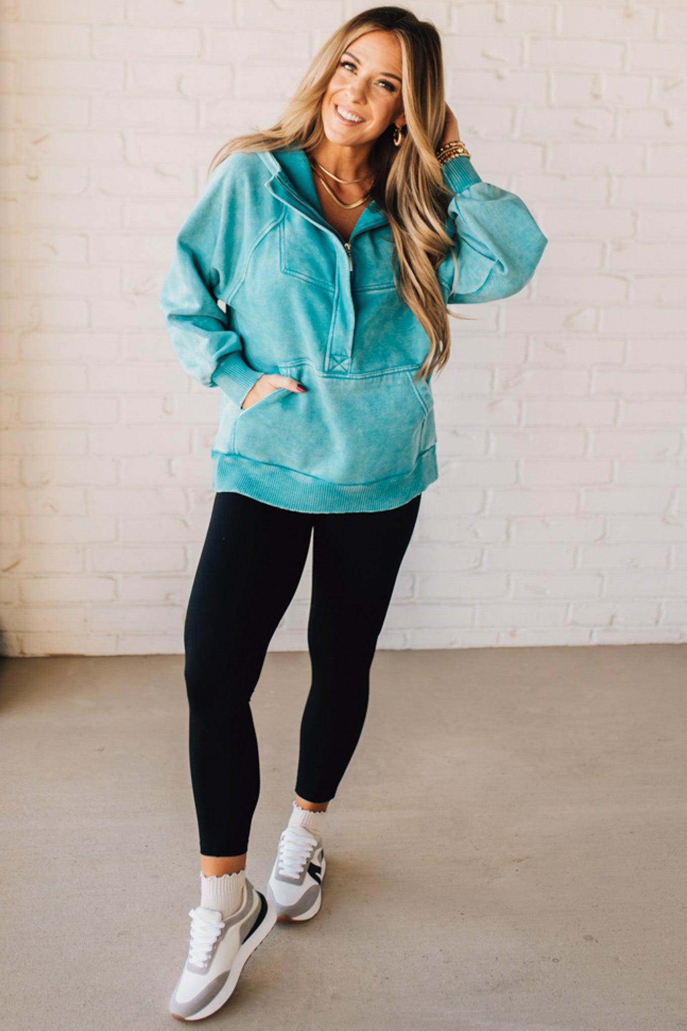 BLONDE WOMAN WEARING A SOLID COLOR ACID WASH FLEECE OVERSIZED 1/4 ZIP KANGAROO POCKET HOODIE.
