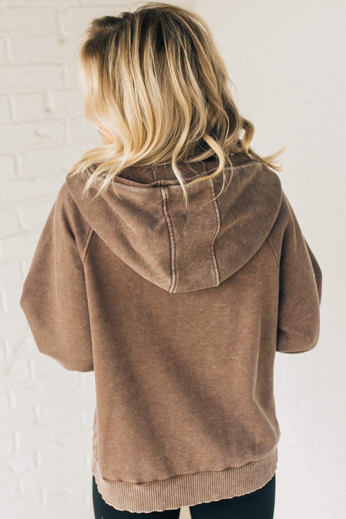 BLONDE WOMAN WEARING A SOLID COLOR ACID WASH FLEECE OVERSIZED 1/4 ZIP KANGAROO POCKET HOODIE.