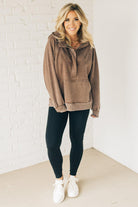 BLONDE WOMAN WEARING A SOLID COLOR ACID WASH FLEECE OVERSIZED 1/4 ZIP KANGAROO POCKET HOODIE.