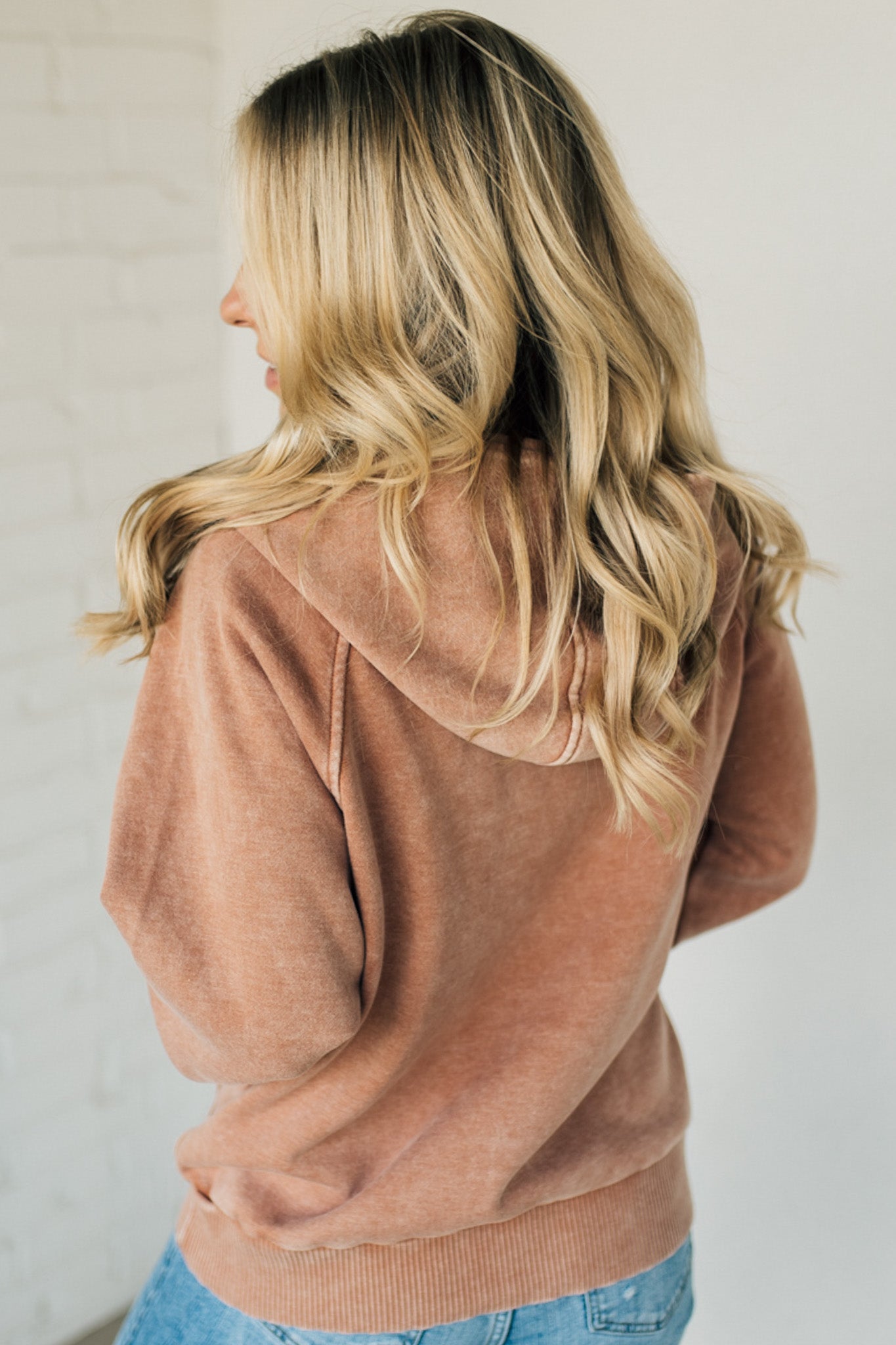 BLONDE WOMAN WEARING A SOLID COLOR ACID WASH FLEECE OVERSIZED 1/4 ZIP KANGAROO POCKET HOODIE.