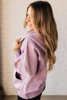 BLONDE WOMAN WEARING A SOLID COLOR ACID WASH FLEECE OVERSIZED 1/4 ZIP KANGAROO POCKET HOODIE.