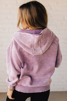 BLONDE WOMAN WEARING A SOLID COLOR ACID WASH FLEECE OVERSIZED 1/4 ZIP KANGAROO POCKET HOODIE.