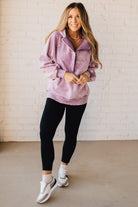BLONDE WOMAN WEARING A SOLID COLOR ACID WASH FLEECE OVERSIZED 1/4 ZIP KANGAROO POCKET HOODIE.