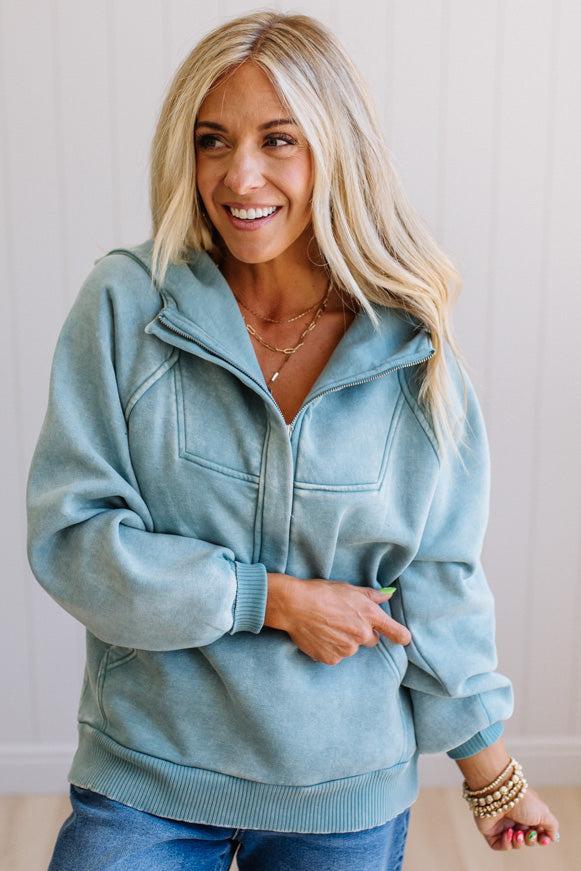 Woman wearing a light blue hoodie with a neutral background