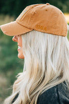 Blonde woman wearing a single color distressed american flag hat.
