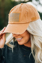 Blonde woman wearing a single color distressed american flag hat.