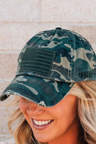Blonde woman wearing a single color distressed american flag hat.