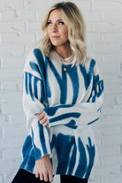 woman wearing an oversized sweater in a trendy ivory and blue graffiti print