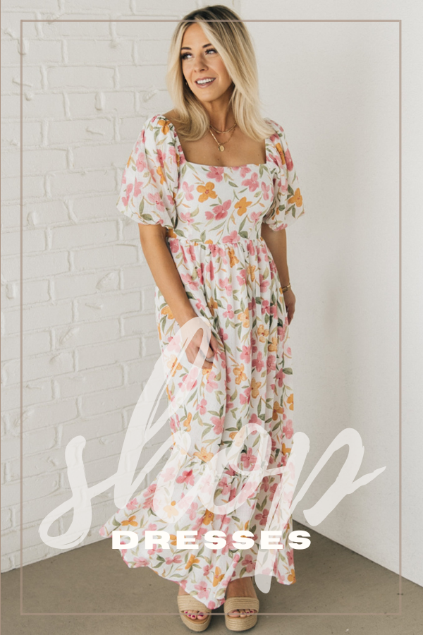 Shop our dresses collection! Blonde woman is modeling an Ivory puff sleeve maxi dress with an all over pink and orange floral pattern