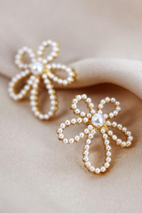 Pearl flower earrings on a beige background