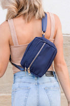 Person wearing a blue crossbody bag on a beach