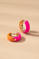 Pair of colorful hoop earrings on a beige background