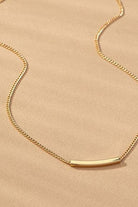 Gold necklace on a beige background