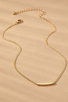 Gold necklace on a beige background