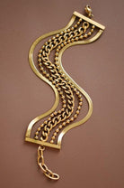 Gold bracelet with chain design on a brown background
