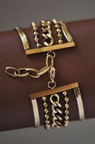 Gold jewelry set with necklaces and pendants on a brown surface