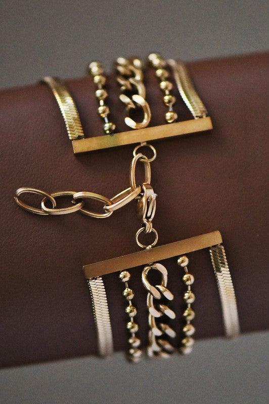 Gold jewelry set with necklaces and pendants on a brown surface