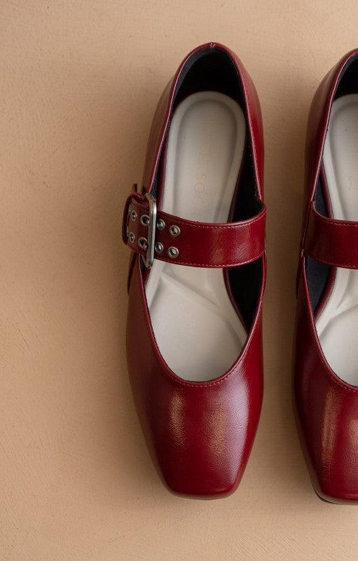 Red shoes with a strap on a beige background