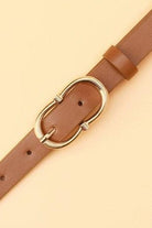 Brown belt with a gold buckle on a beige background