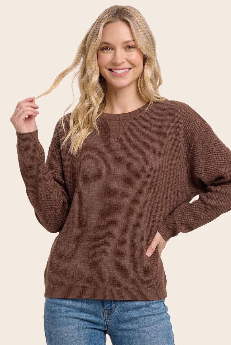 Blonde woman wearing a solid waffle texture sweater with drop shoulder seams and crewneck.