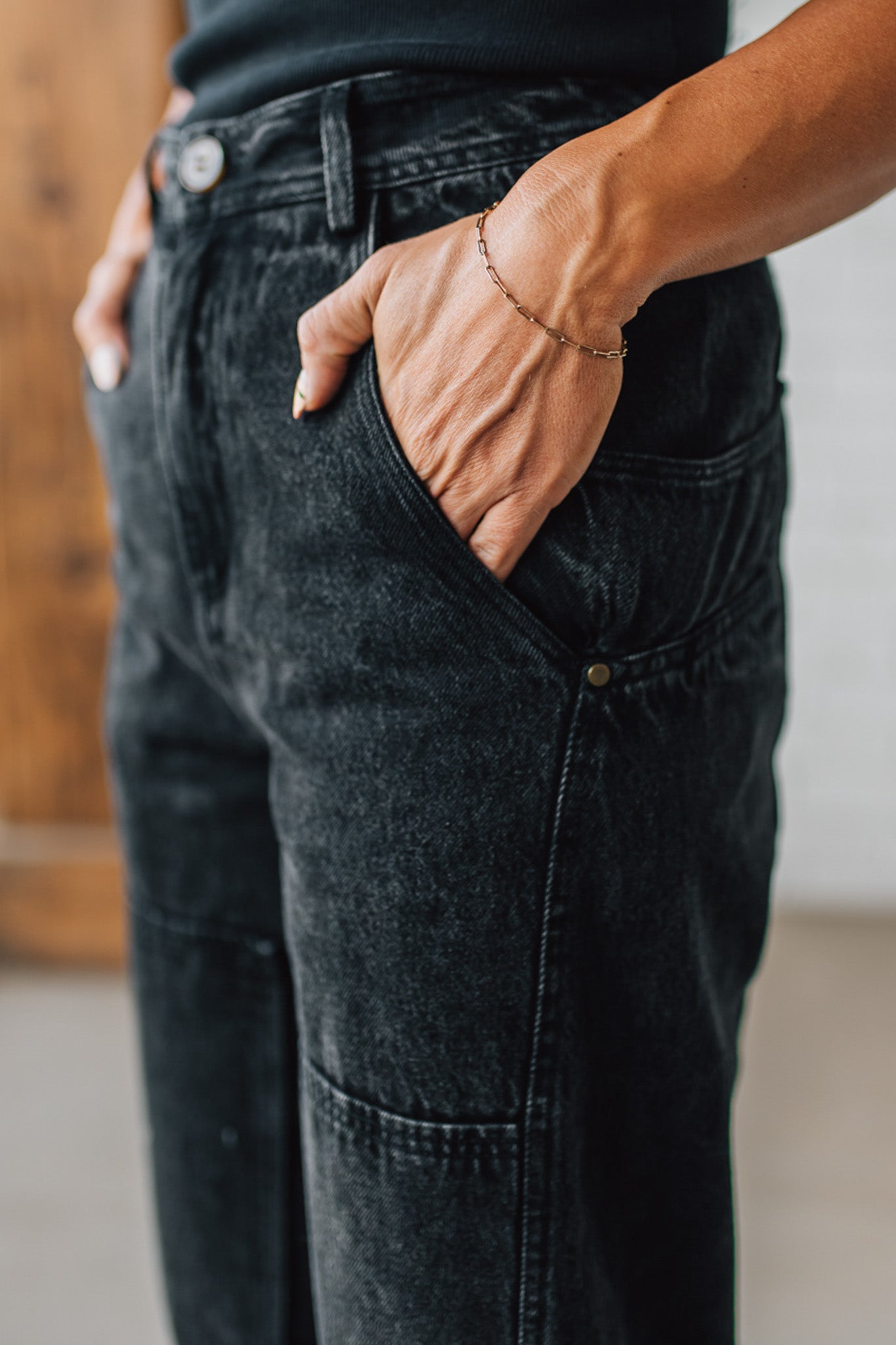 Person wearing black jeans with a blurred background