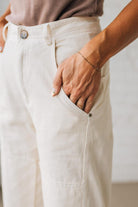 Person wearing white pants with a neutral background