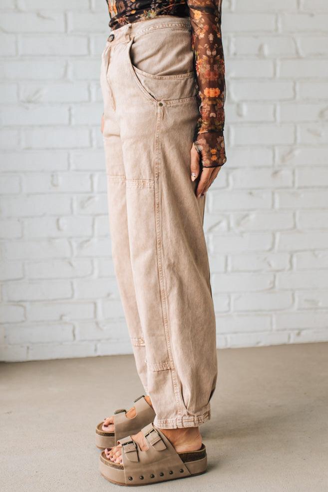 Person wearing beige cargo pants against a white brick wall.