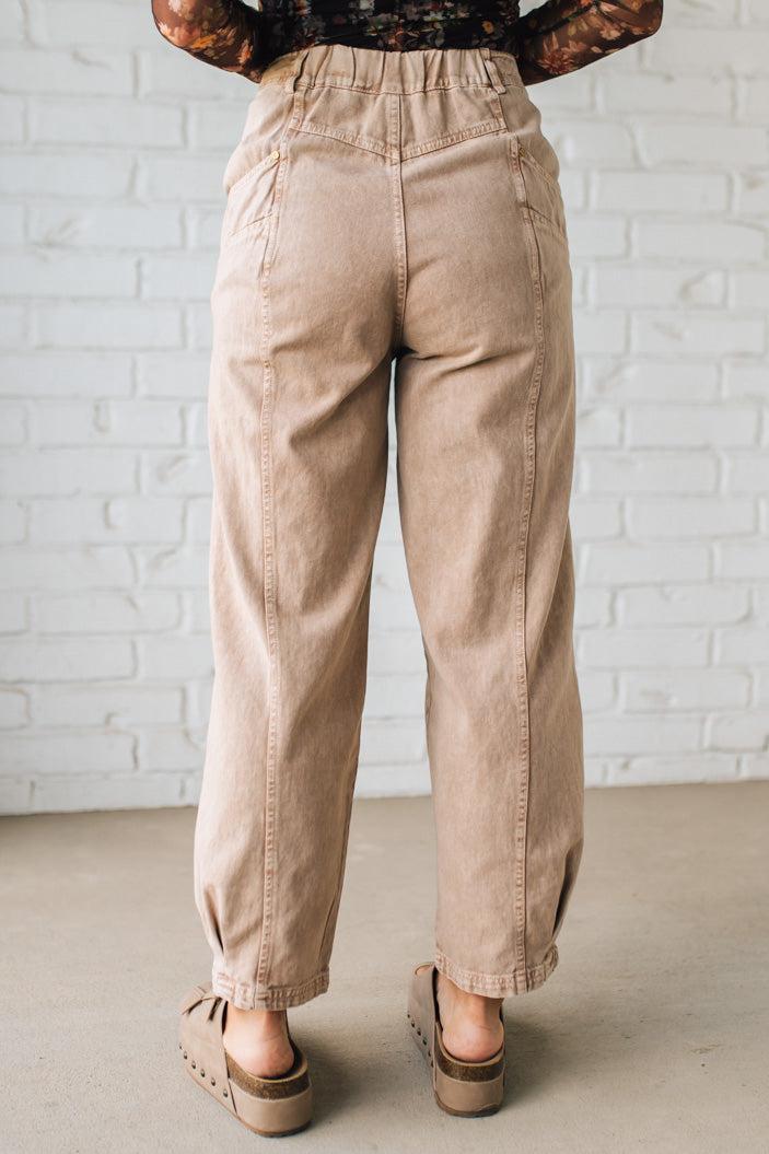 Beige pants worn by a person against a white brick wall.
