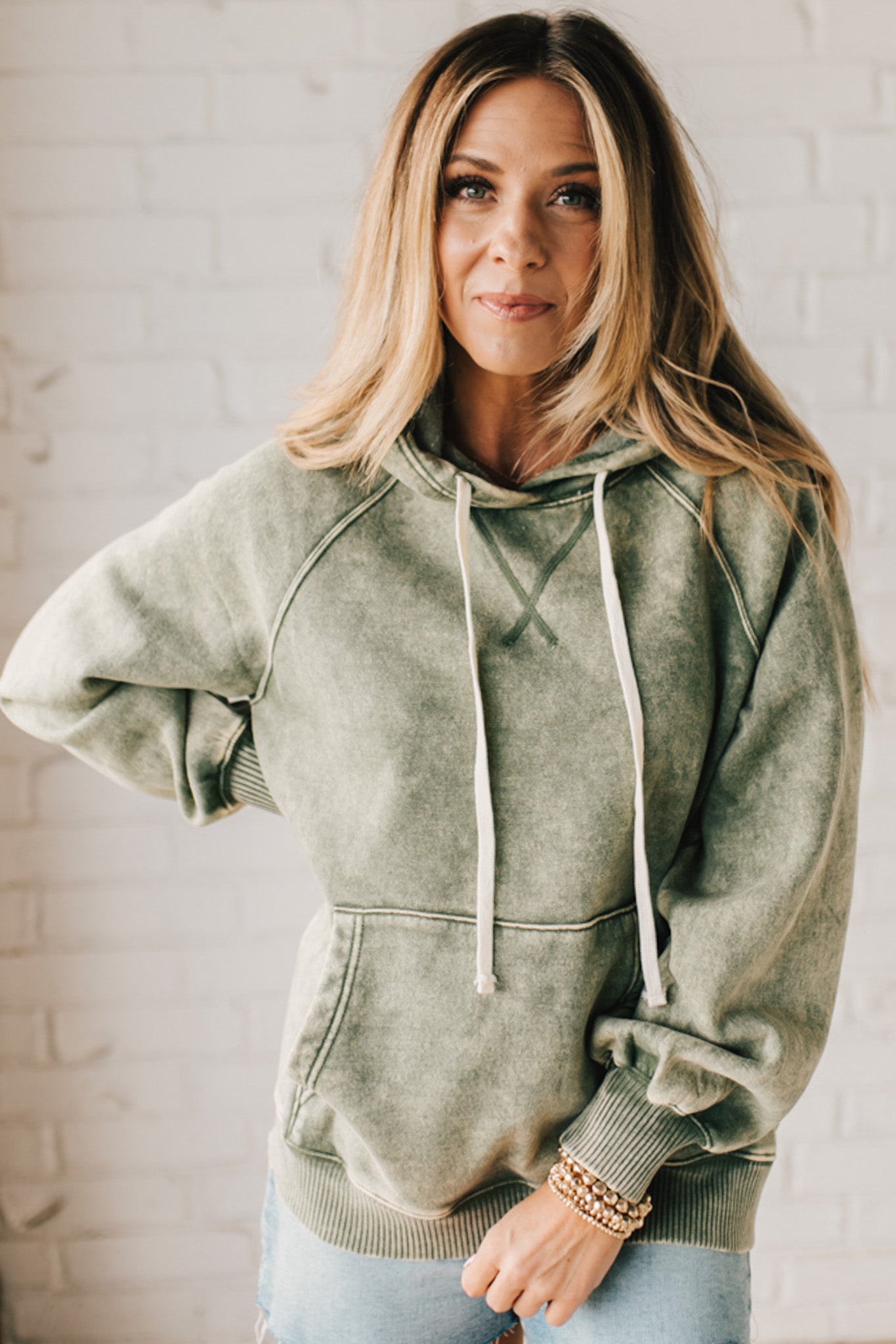 Blonde Woman Wearing a Solid Acid Wash Fleece Hoodie With Front Pocket