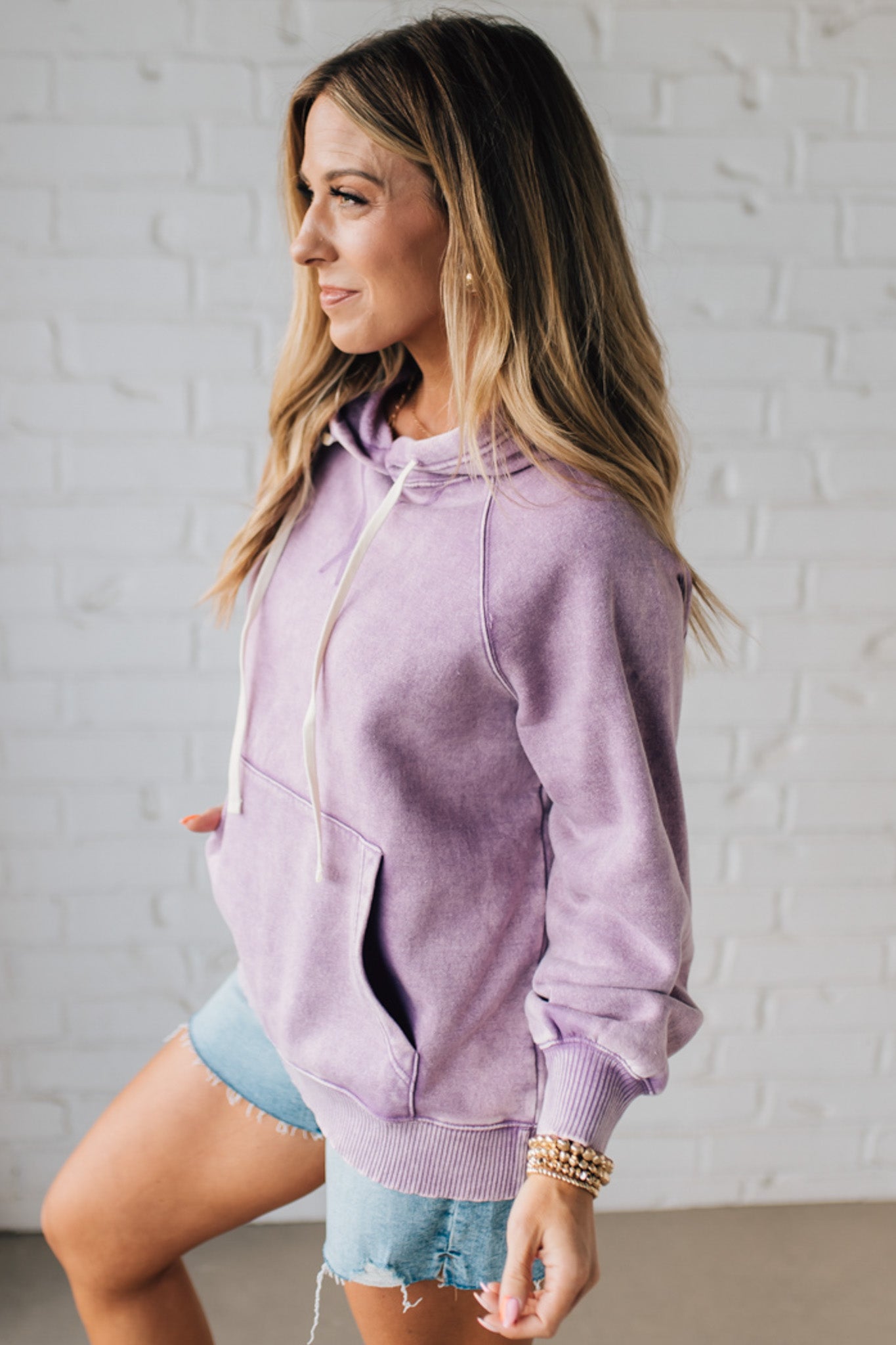 Blonde Woman Wearing a Solid Acid Wash Fleece Hoodie With Front Pocket
