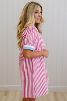 Woman wearing a red and white striped dress against a plain background