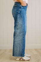 Person wearing blue jeans with a neutral background