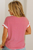 Woman wearing a red and white striped shirt with ruffled sleeves against a plain background