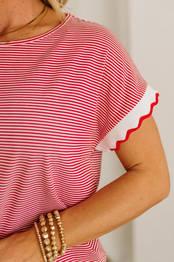 Red and white striped shirt with ruffled sleeves worn by a person.